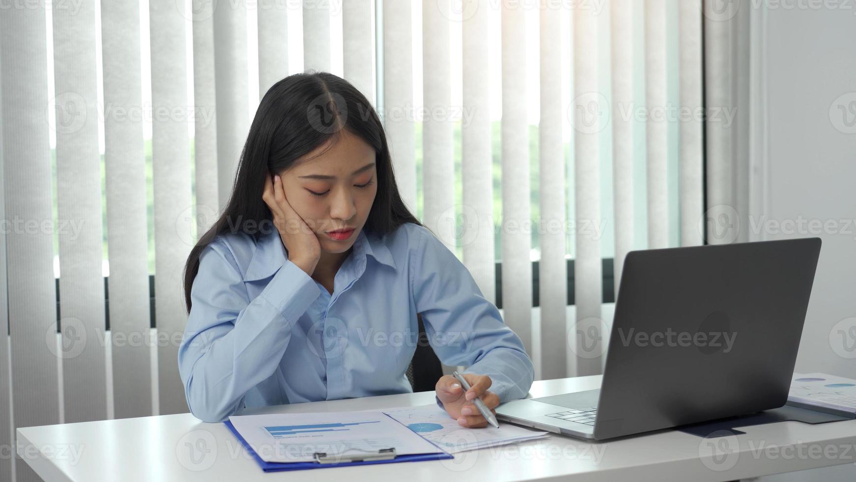 las mujeres asiáticas están aburridas de trabajar en la oficina. foto