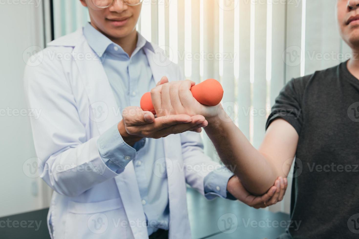 Asian physiotherapists are helping patients lift dumbbells for arm recovery. photo