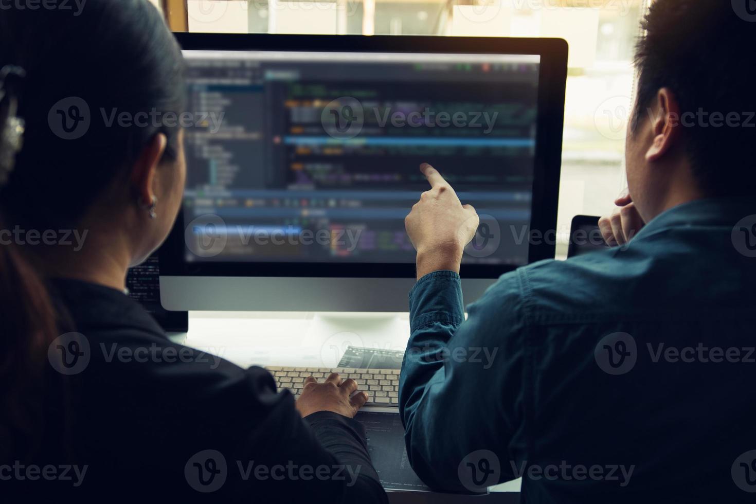 Two software developers are analyzing together about the code written into the program on the computer. photo