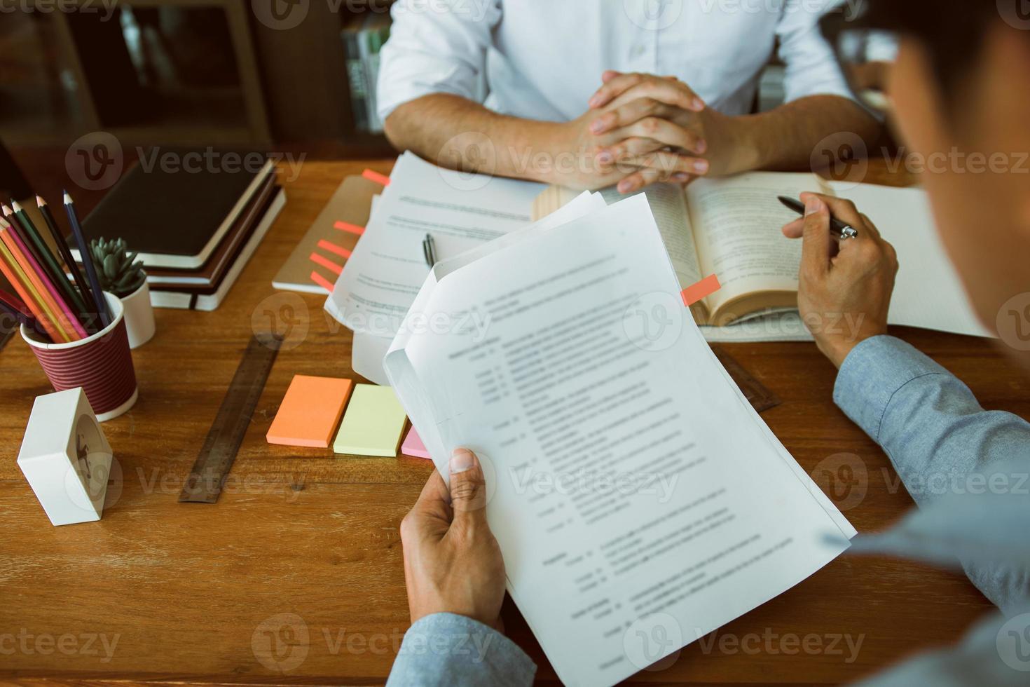 jóvenes universitarios asiáticos que estudian juntos sentados en un escritorio en la biblioteca. foto