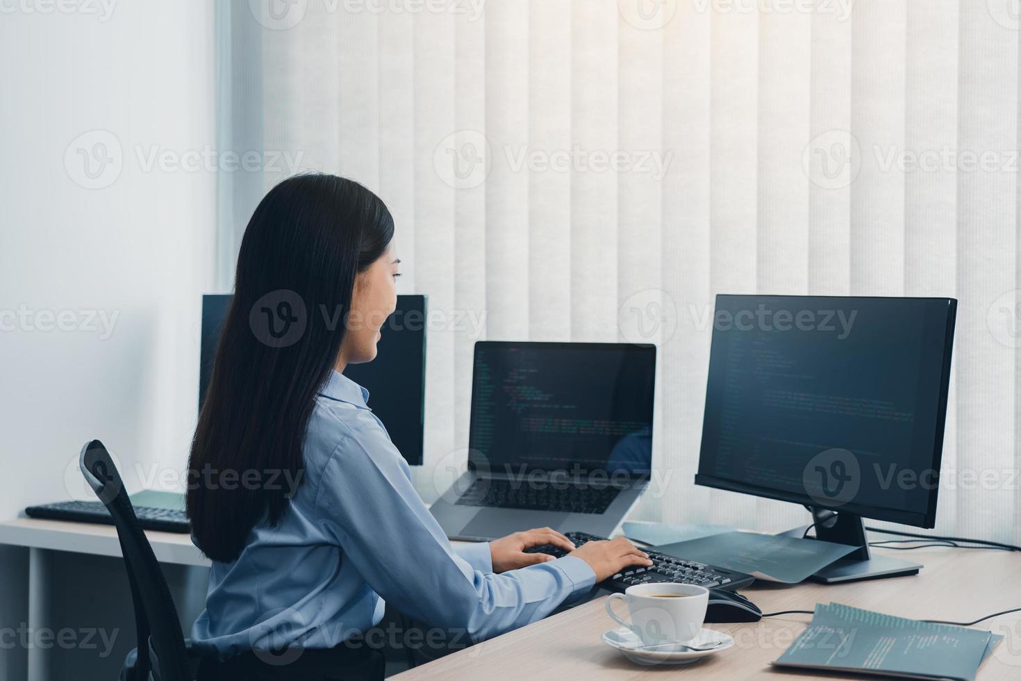 Business woman working on desktop computer monitor professional and sitting at her office desk and working on new software program. photo