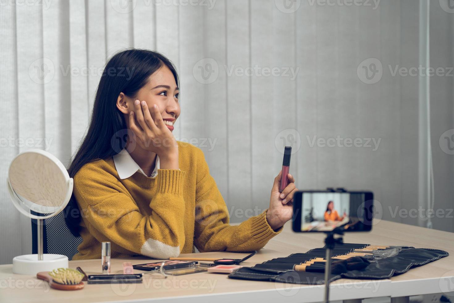 la joven bloguera de belleza asiática está exhibiendo productos cosméticos, así como tutoriales sobre cómo aplicar y grabar tutoriales de maquillaje en las redes sociales. foto