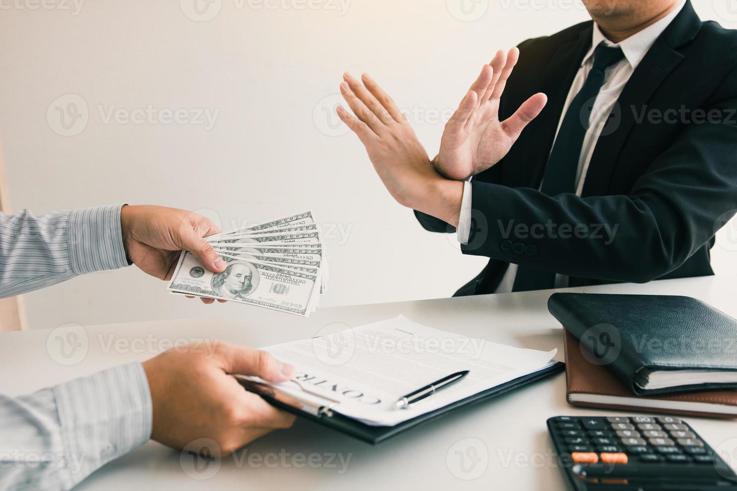 Businessperson refusing bribe given money by partner with anti bribery corruption concept. photo