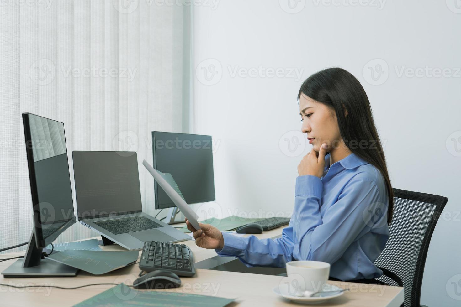 estrese a la mujer asiática mientras codifica el programador de datos en la PC de escritorio mientras trabaja en códigos de computadora en la oficina. foto