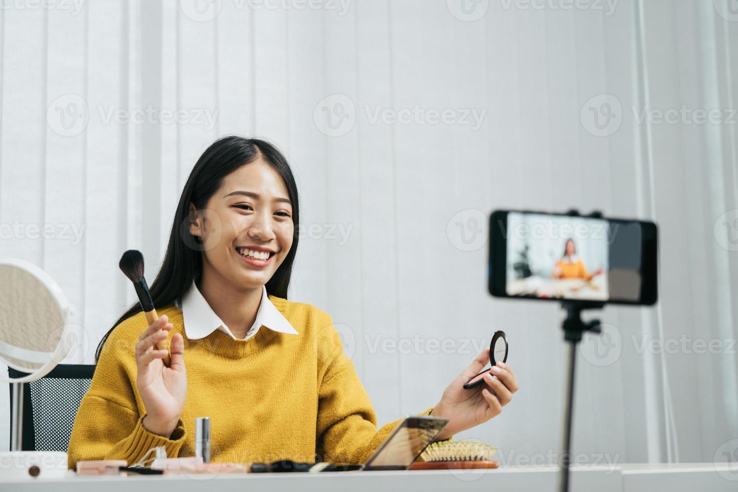 la joven bloguera de belleza asiática está exhibiendo productos cosméticos, así como tutoriales sobre cómo aplicar y grabar tutoriales de maquillaje en las redes sociales. foto