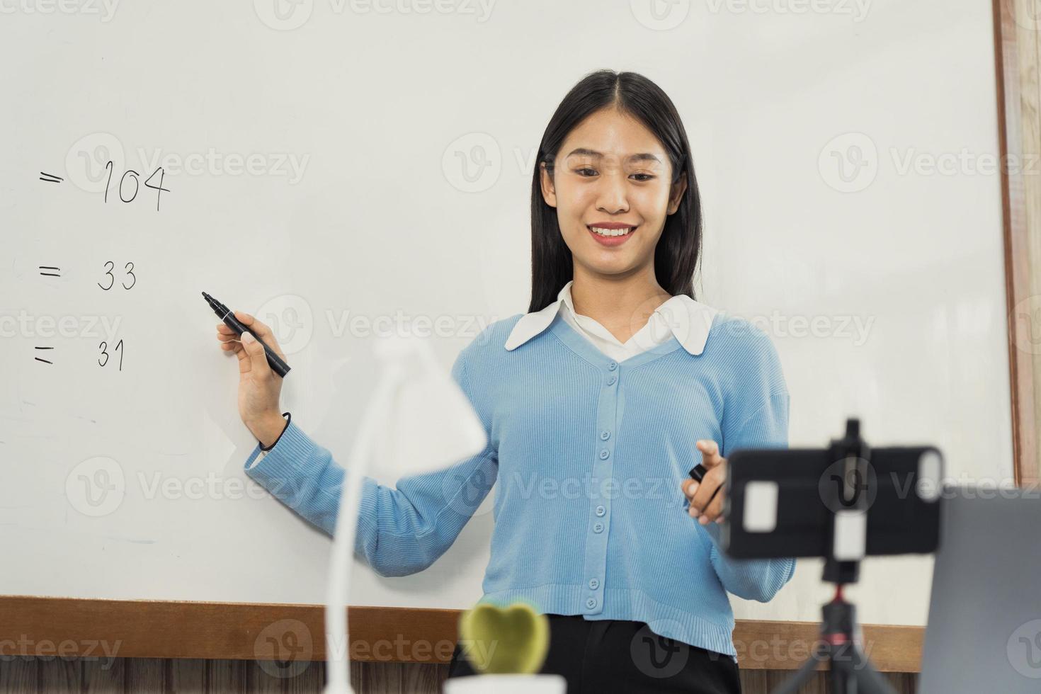 Teacher explaining the numbers on the board while video calling with students studying online. photo