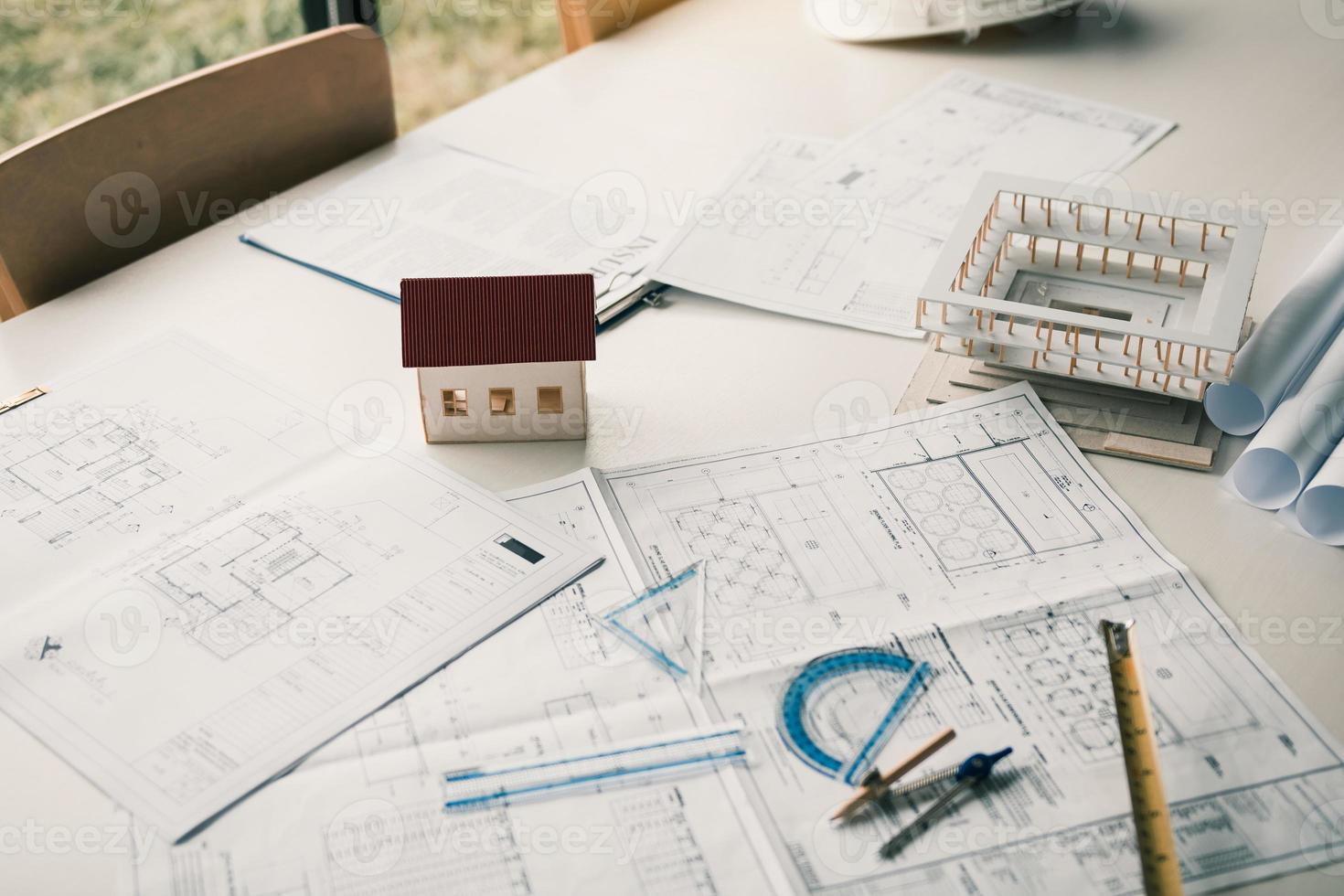 Close up model house on table and blueprint in the office room. photo