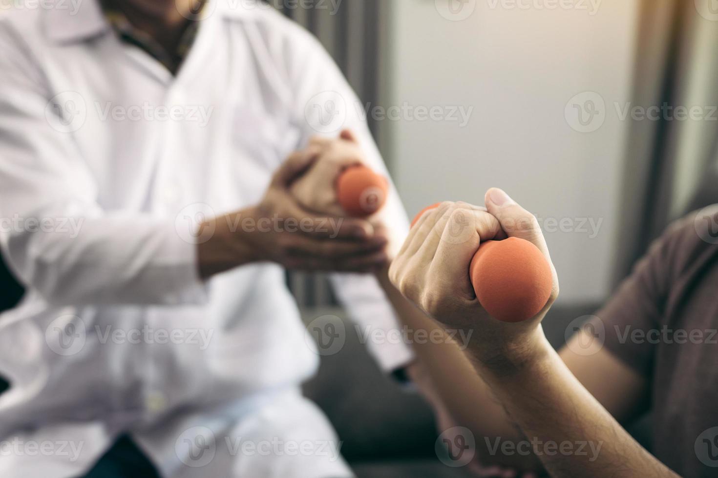 fisioterapeuta asiático ayudando a un paciente a levantar pesas durante su recuperación con pesas en la sala de la clínica. foto