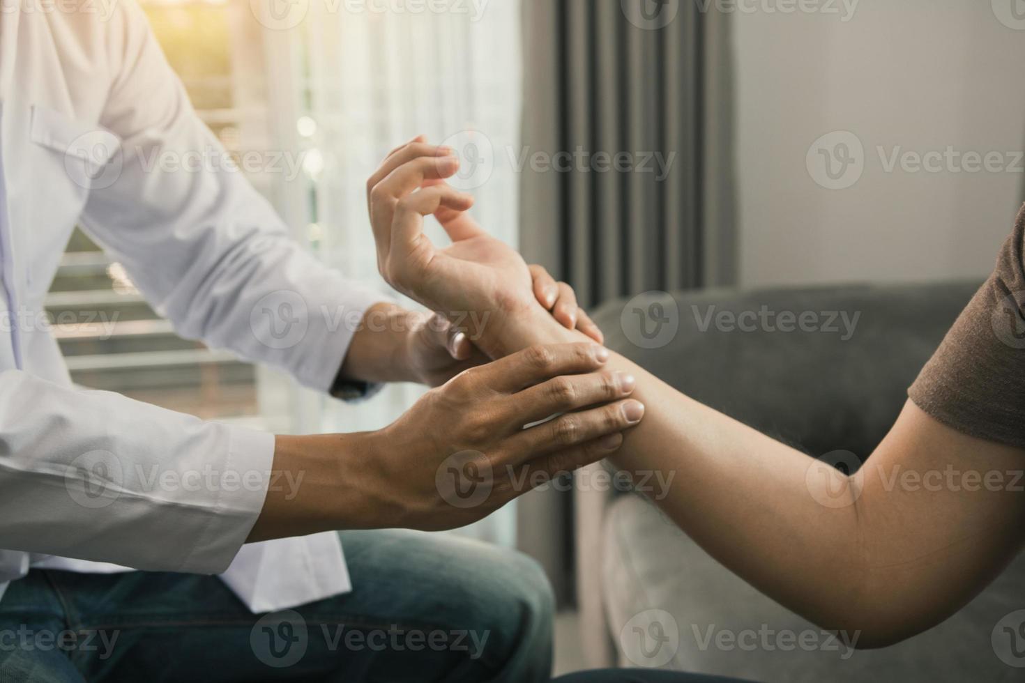 Physical therapist checks the patient wrist by pressing the wrist bone in clinic room. photo