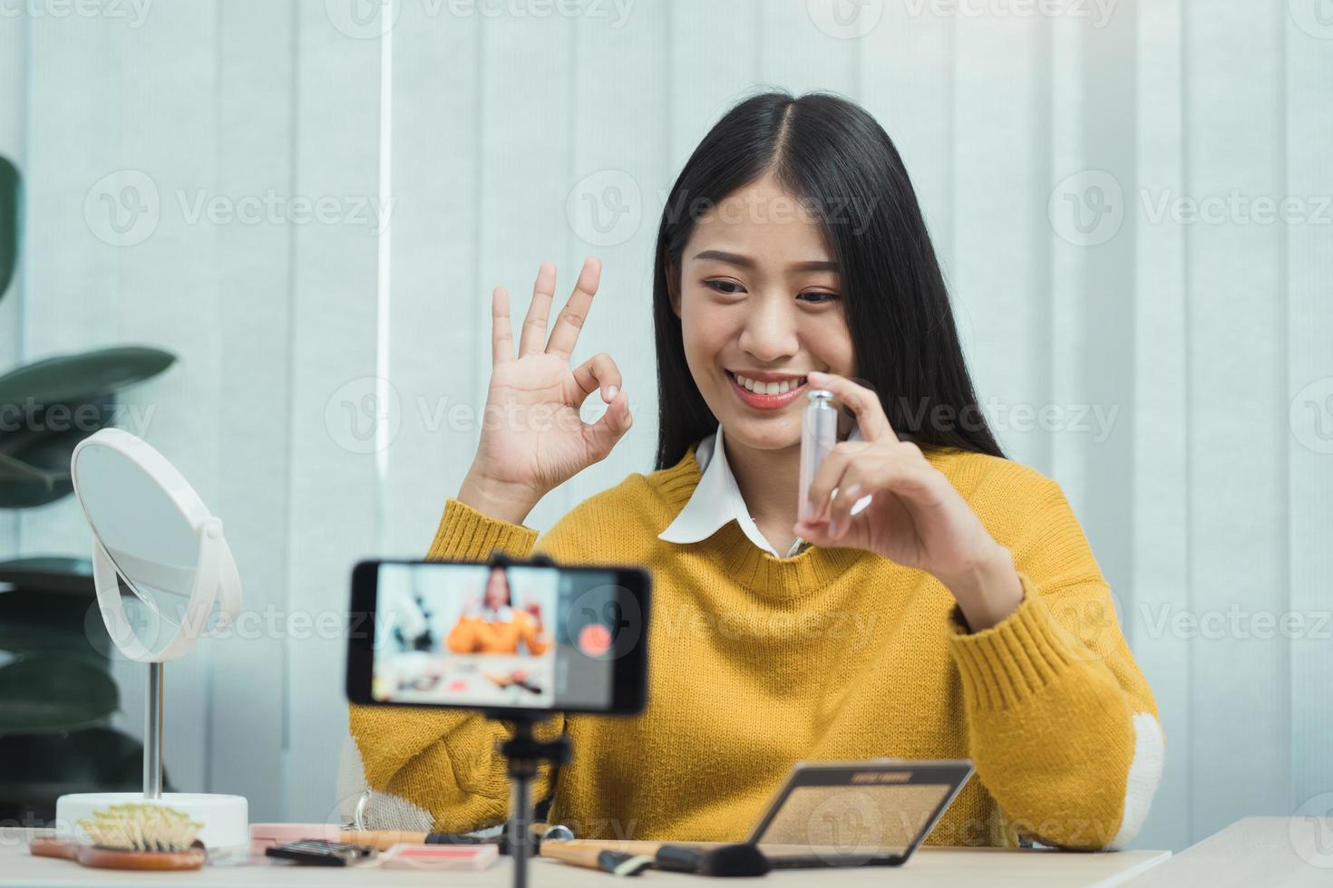 Young Asian beauty blogger is showcasing cosmetic products as well as tutorials on how to apply and record makeup tutorials on social media networks. photo