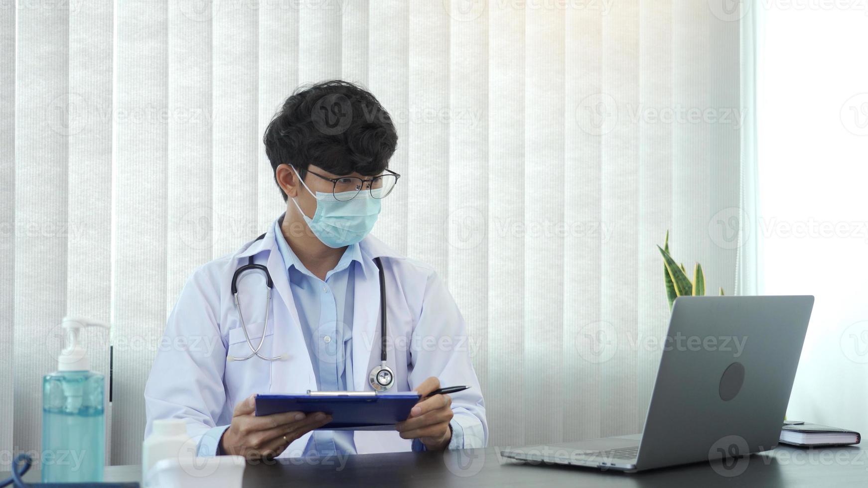 Doctor hand holding pen writing patient history list on clipboard about medication and treatment. photo