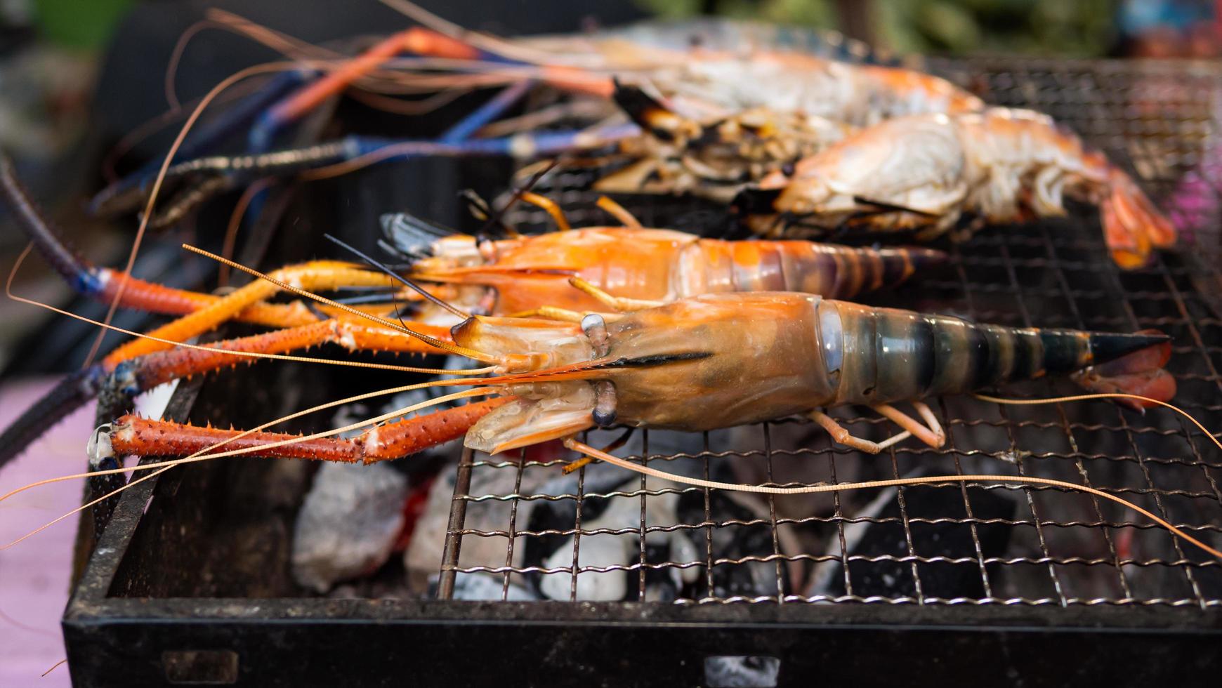 los camarones se asan en la parrilla o en la estufa. cocinar mariscos a la parrilla en casa. camarones grandes en la estufa. se está poniendo naranja y está maduro. foto