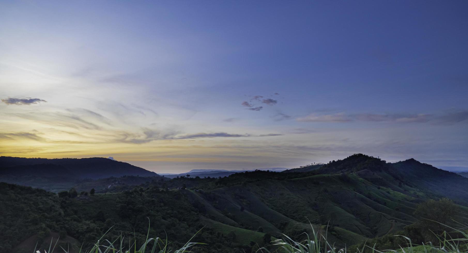 Intricate mountain scenery in the morning when the sun is rising. The wind blows trees and grass. Blown by the wind. Nature on the mountain in the morning. Fresh air. photo