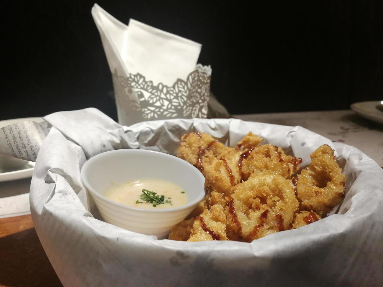 Fried Calamari Topped with sweet sauce. Salad sauce topped with coriander. Golden crispy food. photo