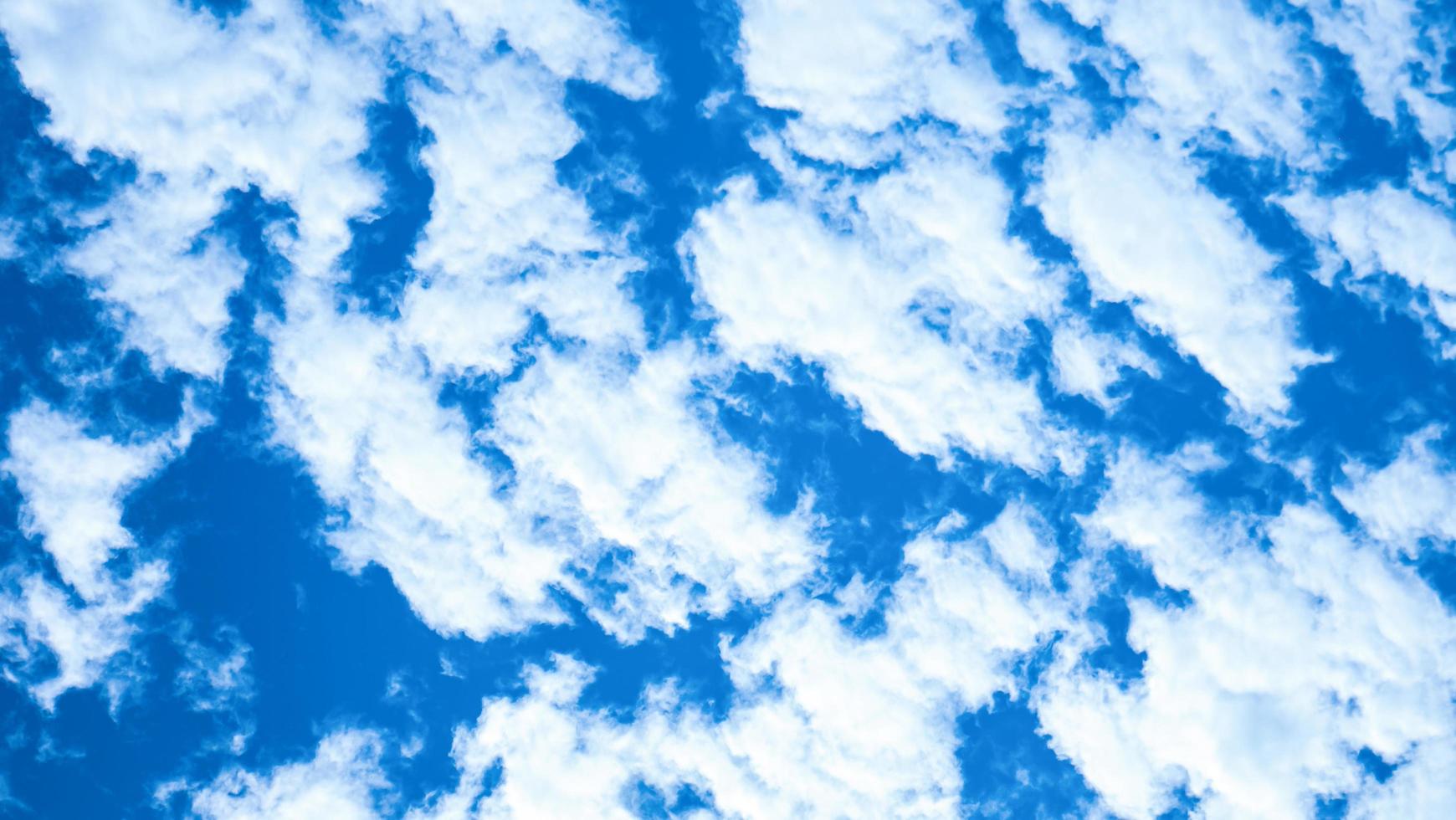 el cielo azul y la nube blanca se usan para el fondo. el cielo es azul brillante con nubes blancas dispersas. imágenes de la naturaleza con cielo y nubes, perfectas para usar como fondo de pantalla, pancarta o fondo. foto