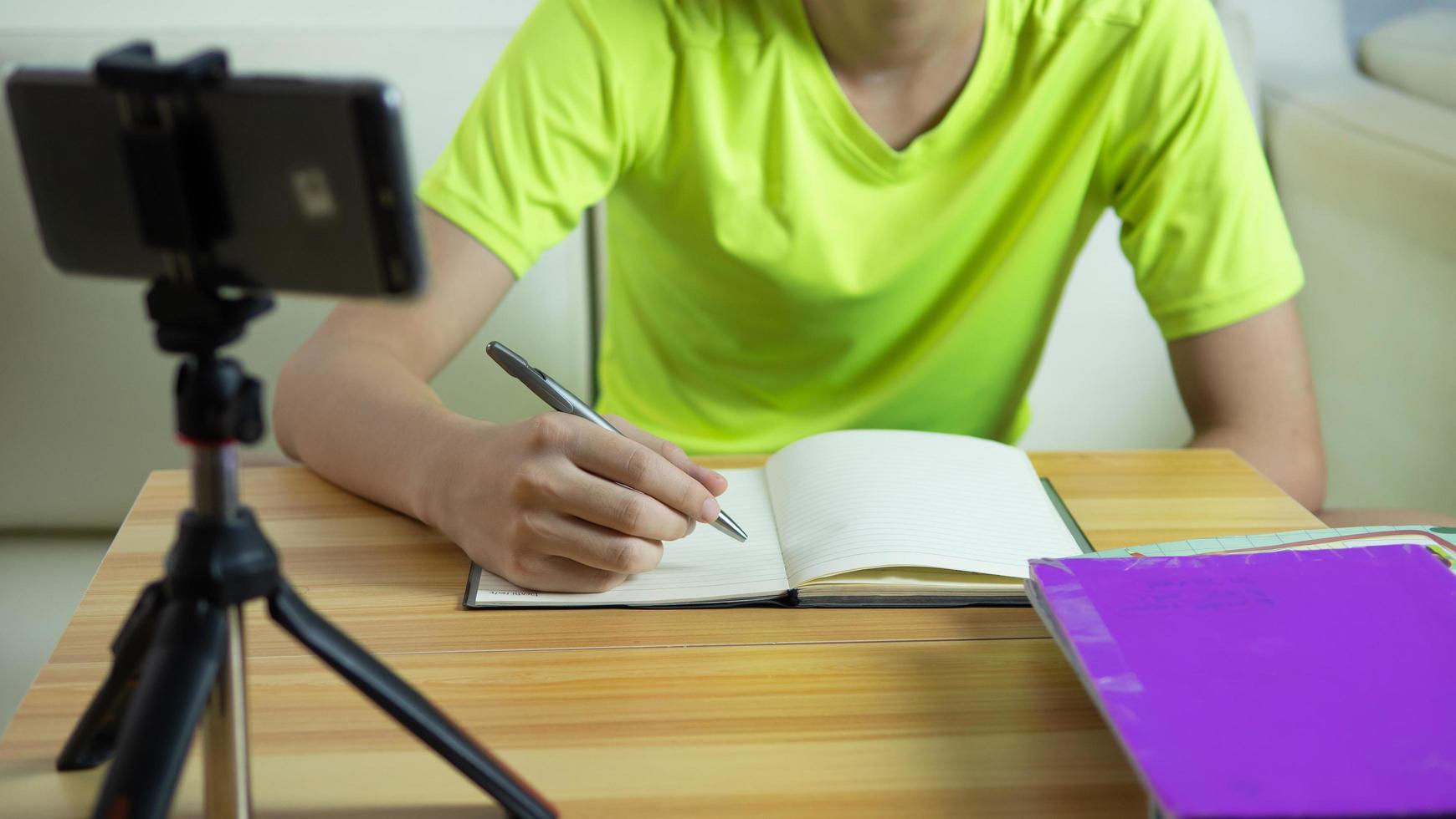 boy is studying online at home with Smart Phone via the Internet during quarantine or Lockdown during the Covid-19 virus outbreak. Study Online via Social Media. photo