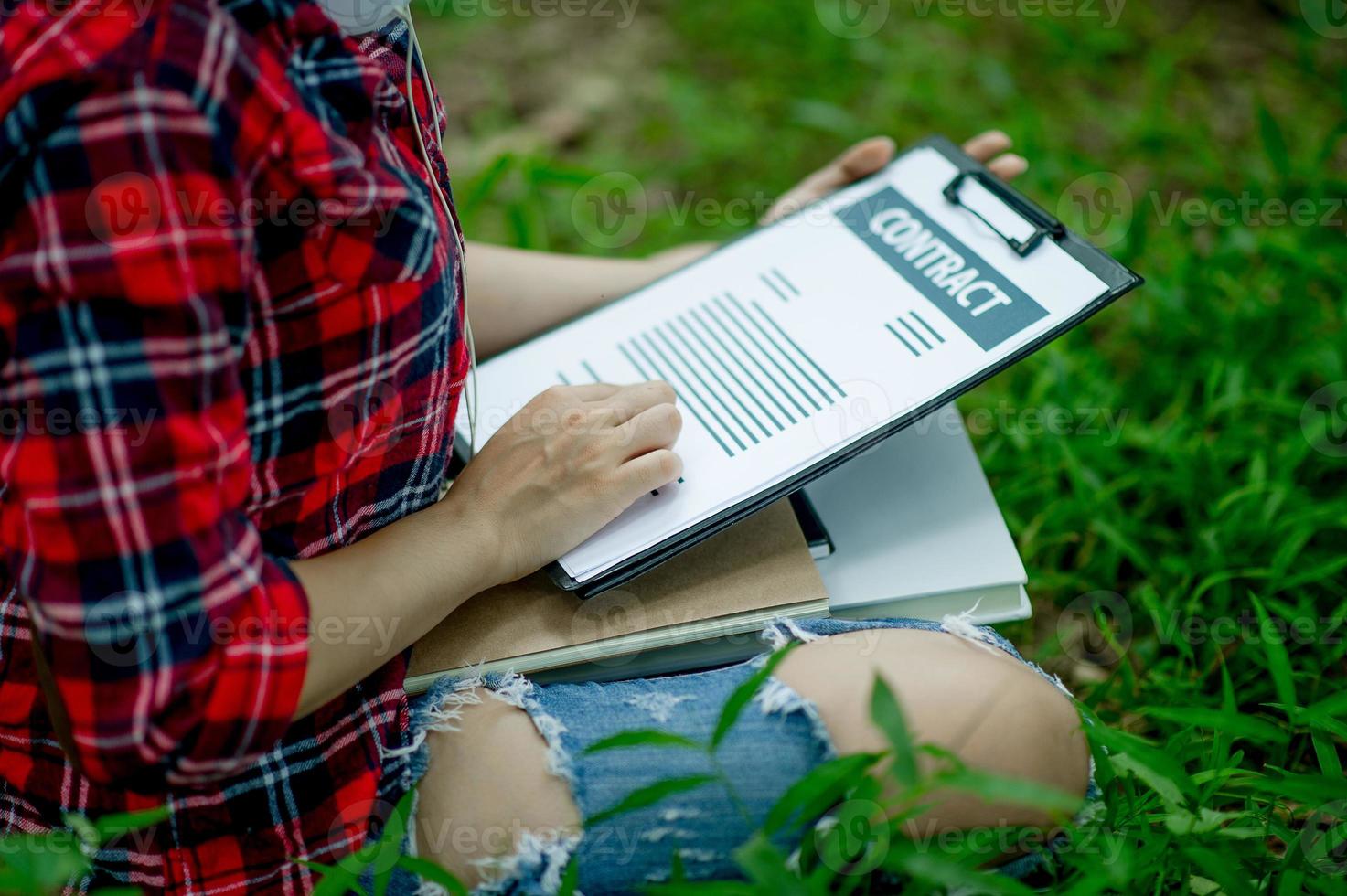 Hand of staff, marketing manager pointing to business documents and sitting under the tree - Business ideas photo