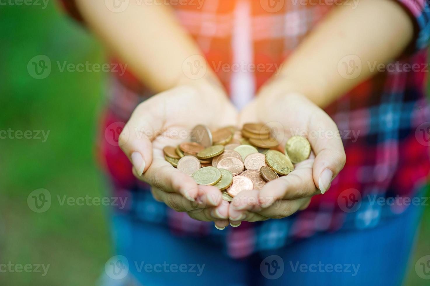 mano femenina sosteniendo una moneda y feliz con los ahorros. y copiar espacio foto