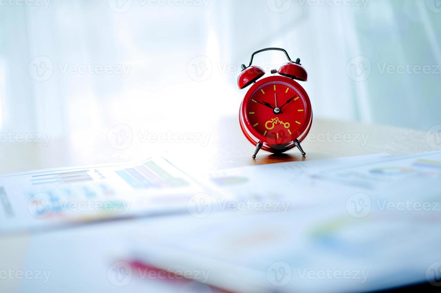 Old red alarm clock, red alarm clock Placed in the workspace. White room Beautiful colors. photo