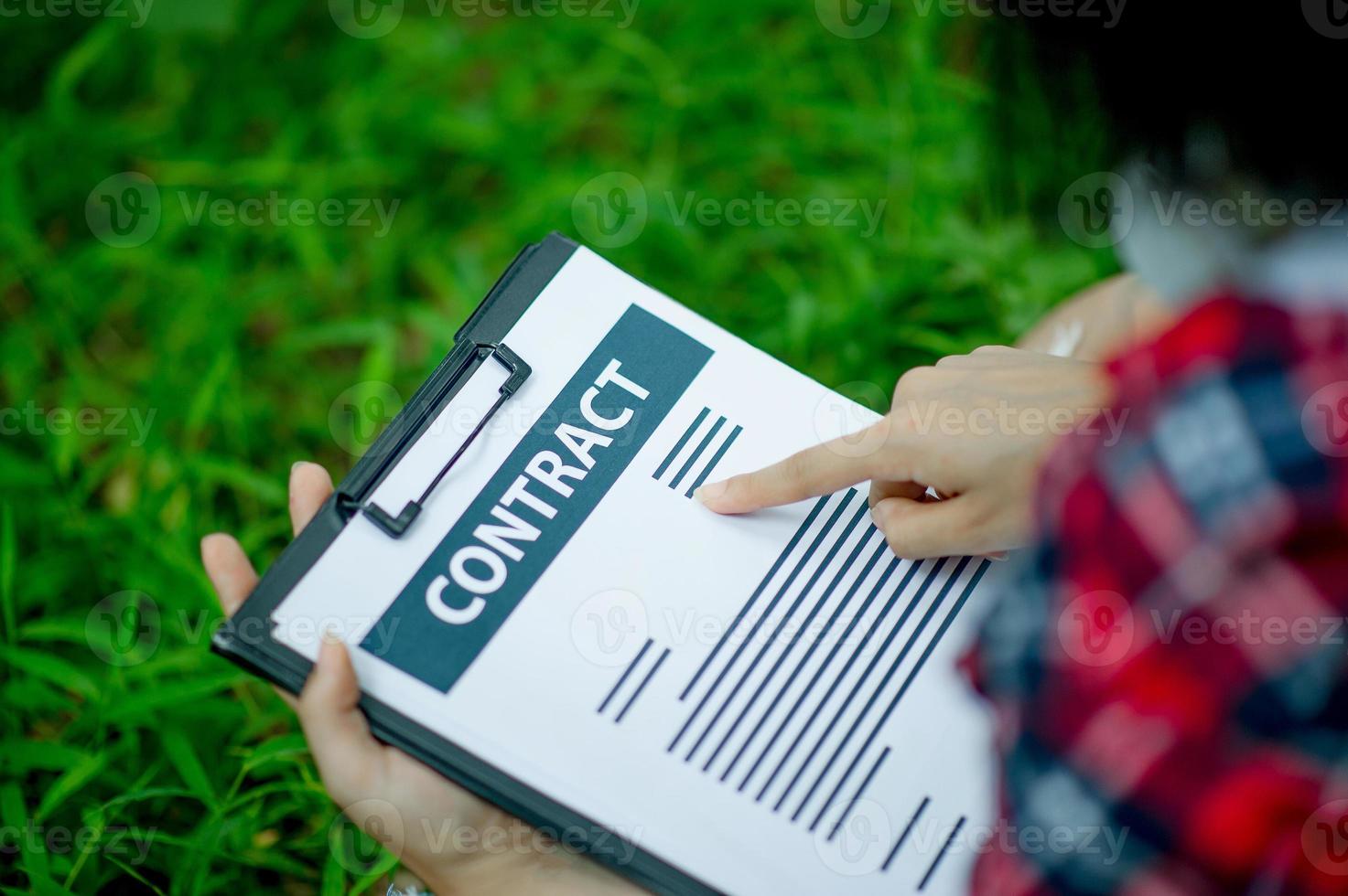 Hand of staff, marketing manager pointing to business documents and sitting under the tree - Business ideas photo
