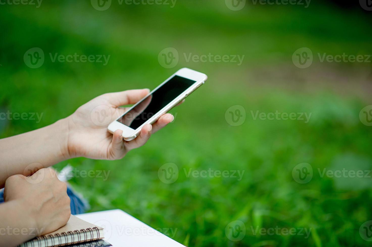 niña jugando teléfono a mano para comunicación en línea y contacto use camisa roja y fondo verde y hay un espacio de copia. foto