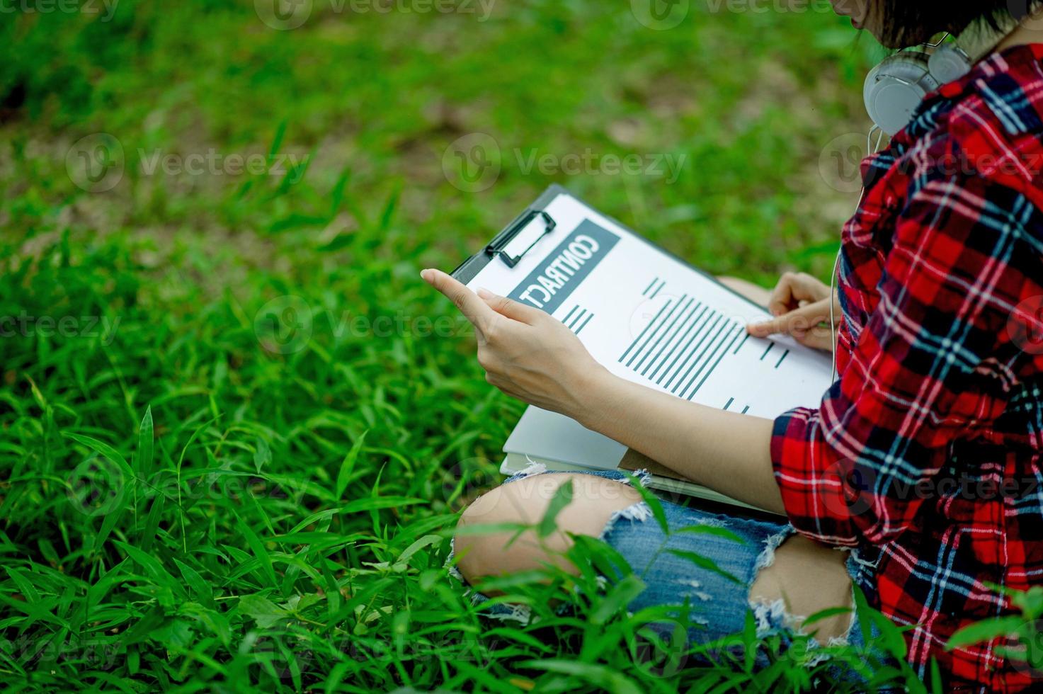Hand of staff, marketing manager pointing to business documents and sitting under the tree - Business ideas photo