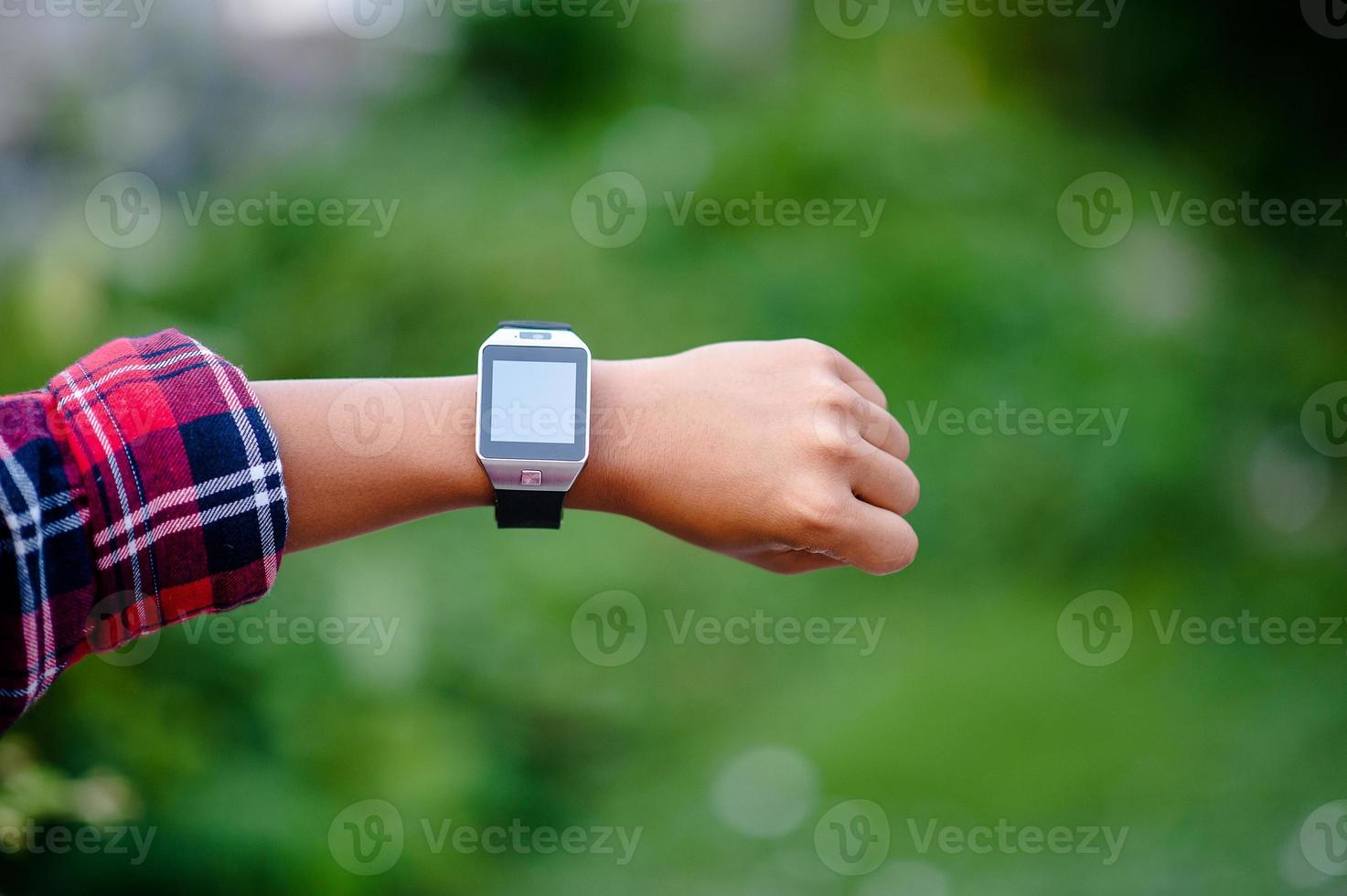 las manos y los relojes digitales de los niños miran la hora en la muñeca. la orientación es puntual. foto