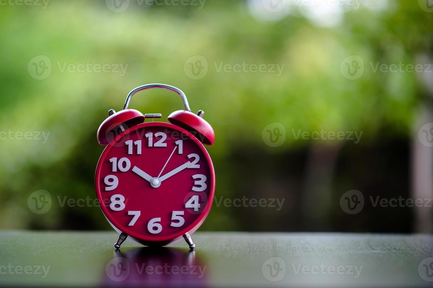 Black Antique Clock Red Metal Alarm Clock on Red Valentine's Day Love Concept Red clock on the table. photo