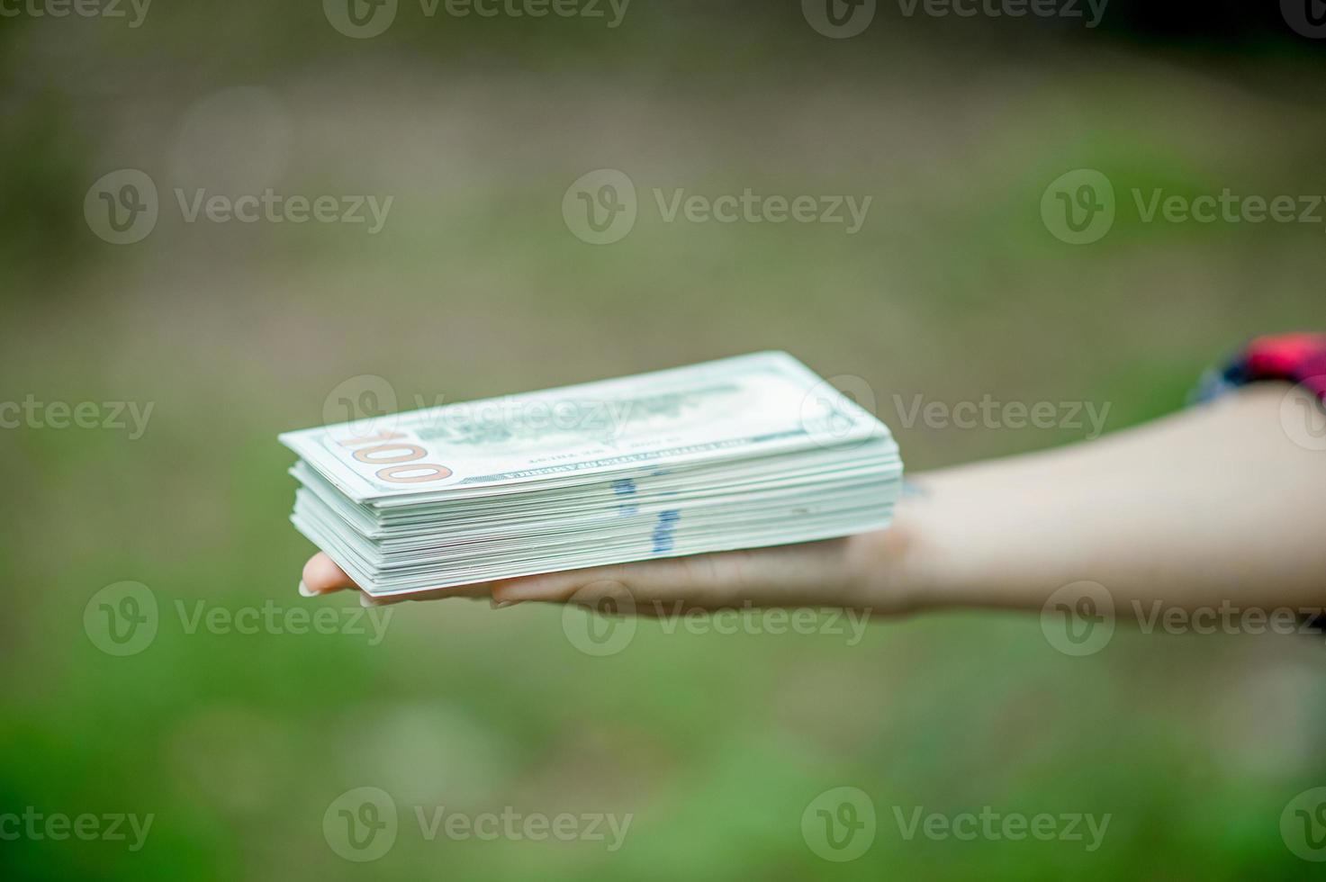 retrato de una joven feliz con un dólar en la mano. y hay un espacio de copia. foto