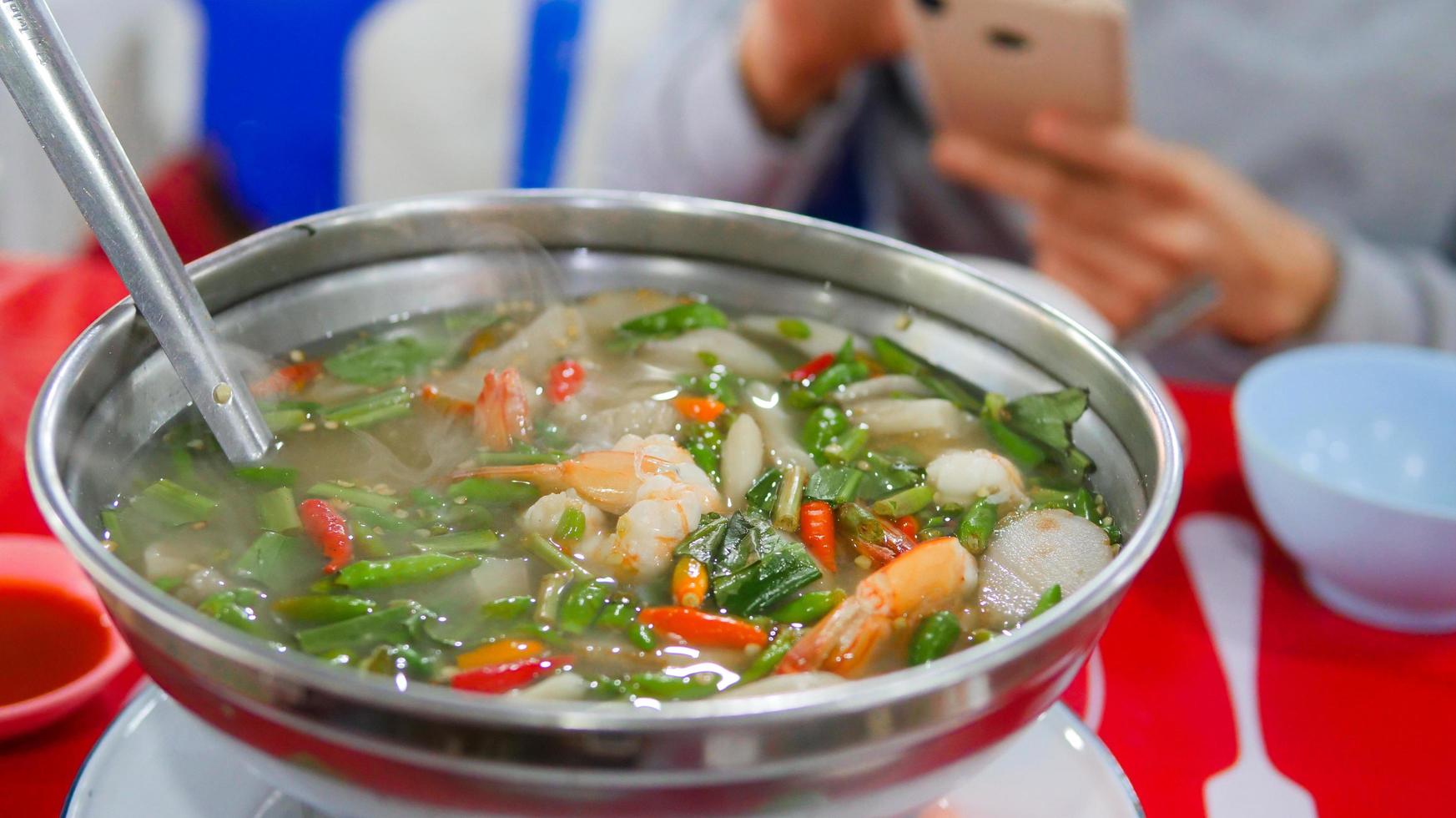 Clear soup Tom Yum Kung. Famous food of Thailand. It is sour, spicy, mellow and delicious. Ingredients fresh shrimp, various types of mushrooms, kaffir lime leaves, fresh chili, galangal, lemongrass, photo