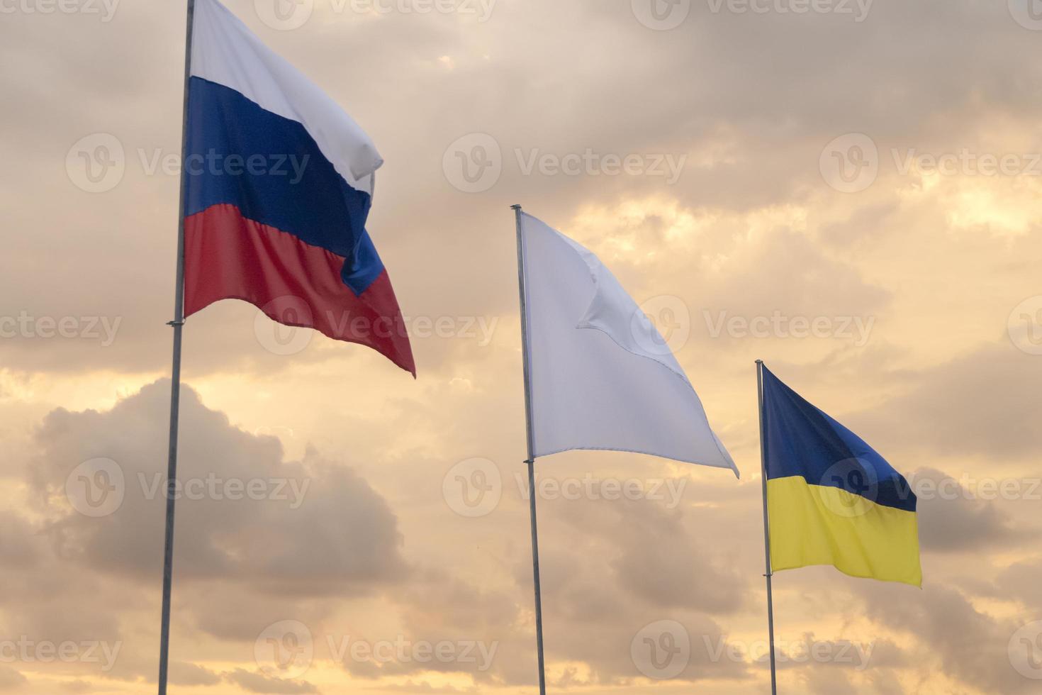 Flags waving at sunset. Russia and Ukraine. photo