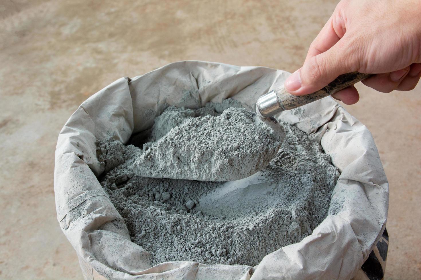 Cement powder with trowel put in bag package photo