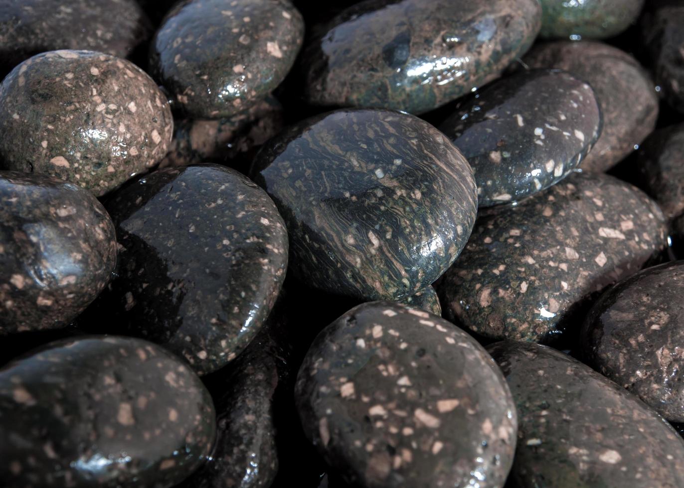 Round black stone on ground beside the waterfall photo