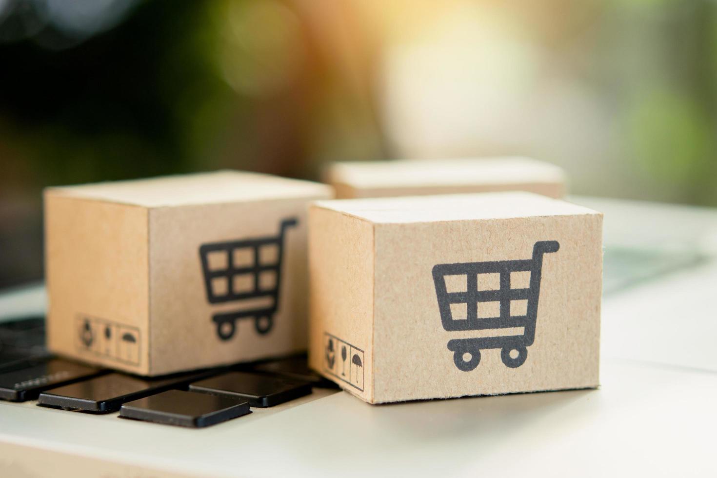 Shopping online. Cardboard box with a shopping cart logo on laptop keyboard. Shopping service on The online web. offers home delivery. copy space photo