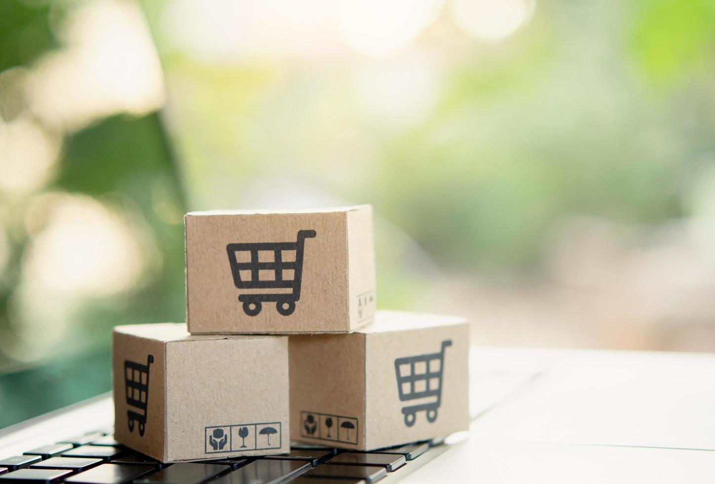 Shopping online. Cardboard box with a shopping cart logo on laptop keyboard. Shopping service on The online web. offers home delivery. copy space photo