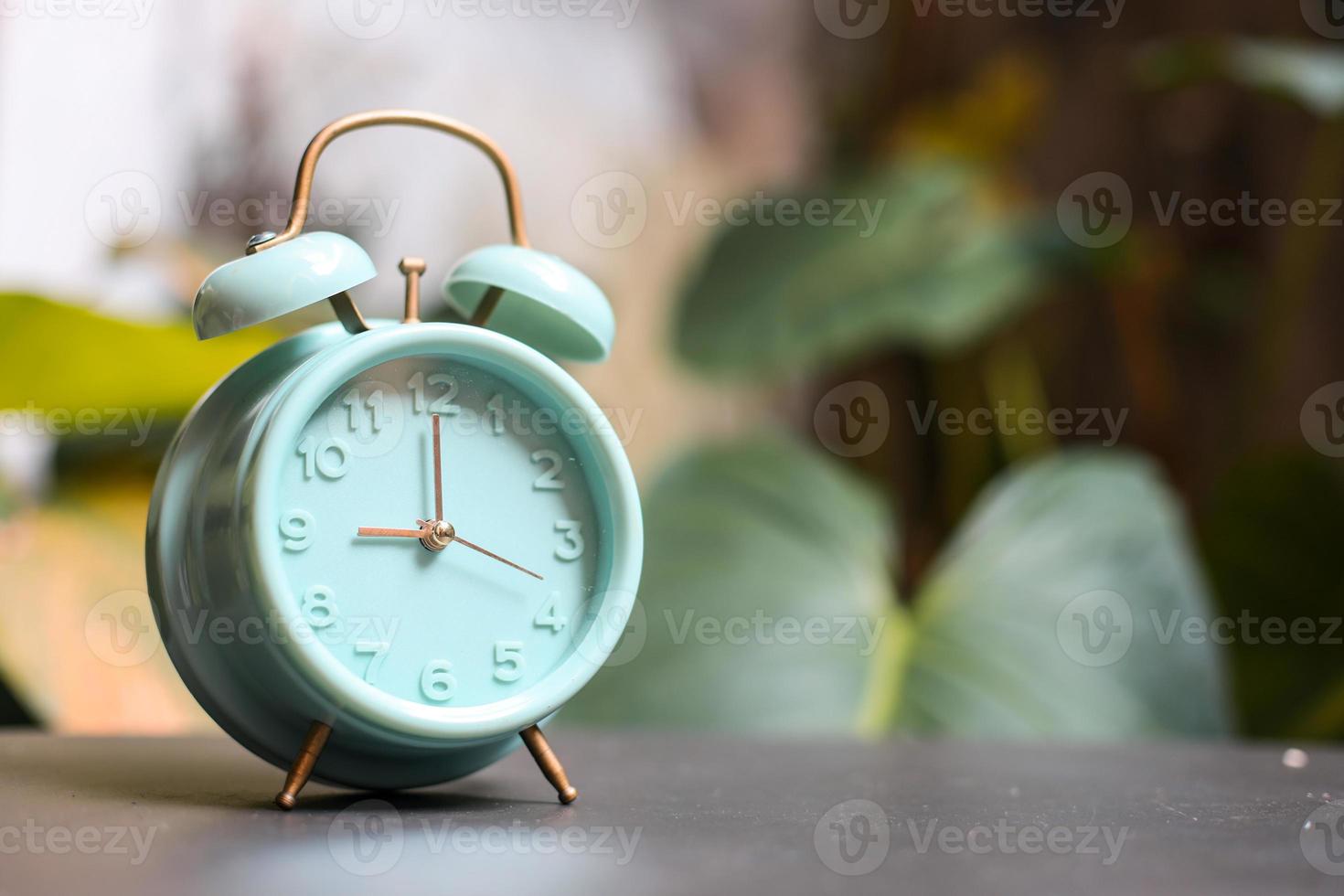 Classic turquoise alarm clock showing 9 oclock photo