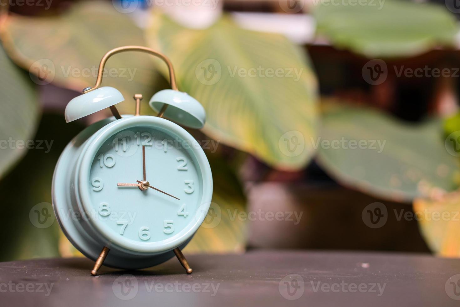 Classic turquoise alarm clock showing 9 oclock photo