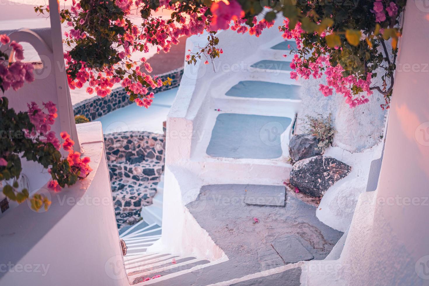 escena de viaje artístico. fantástico paisaje de puesta de sol de viaje romántico y destino de pareja de vacaciones. concepto de aventura de verano de lujo. maravillosa vista del pueblo de oia, santorini, grecia. escaleras, flores foto