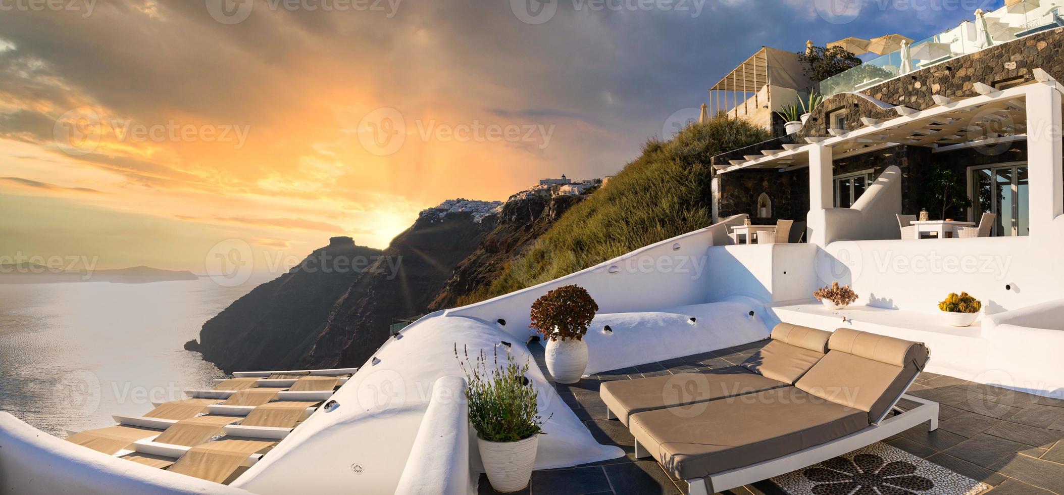 24.07.21. Santorini island, Oia sunset caldera scene, two sun beds, loungers, amazing sun rays sea view horizon colorful sky calm relax. Inspirational beach resort hotel. Luxury Greece travel vacation photo