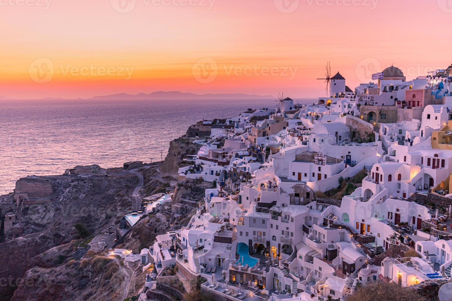 vista nocturna del atardecer del pueblo griego tradicional oia en la isla de santorini en grecia. santorini es un destino turístico icónico en grecia, famoso por sus puestas de sol y su arquitectura blanca tradicional foto