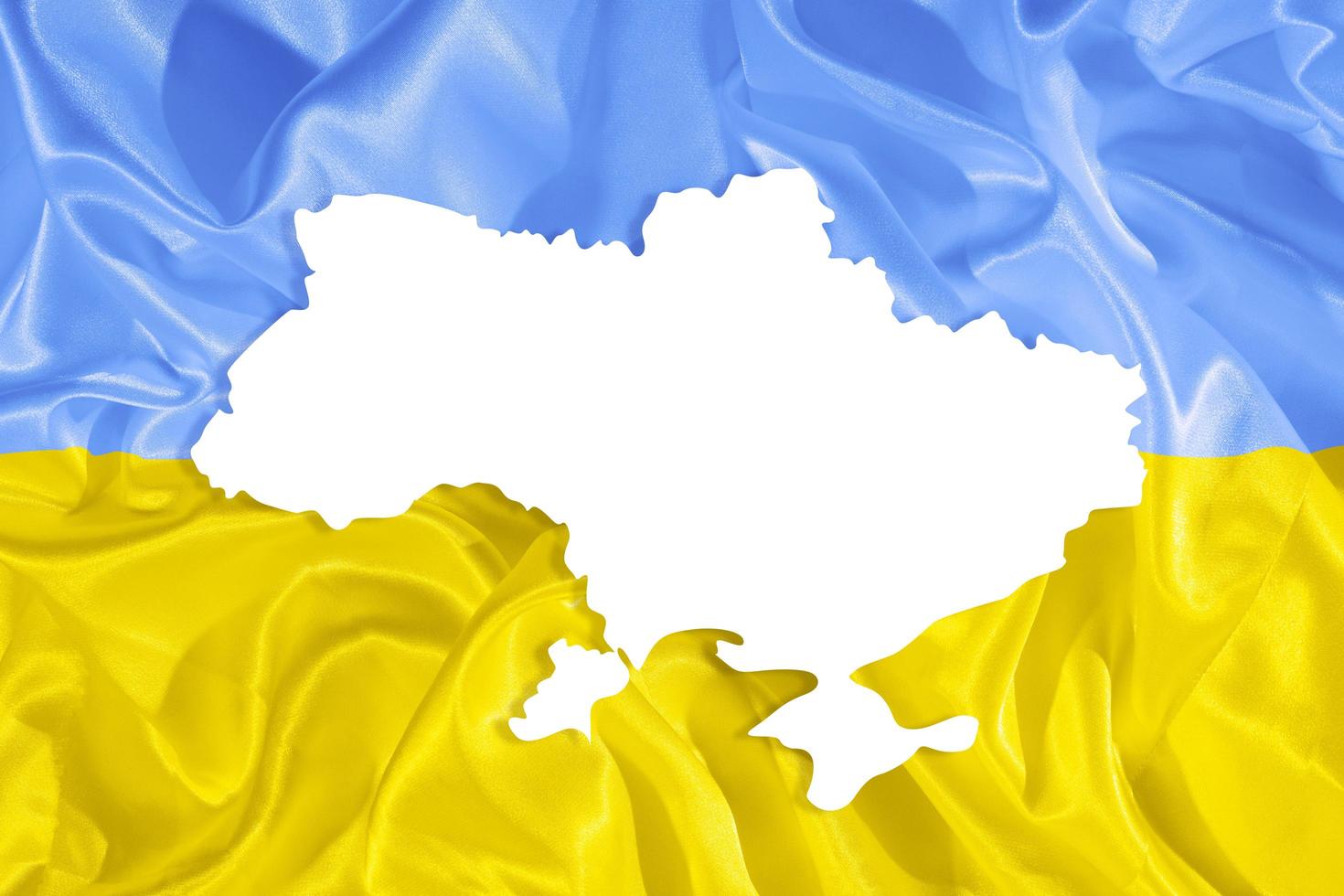 Ukrainian yellow and blue fabric flag and country map silhouette with copy space photo