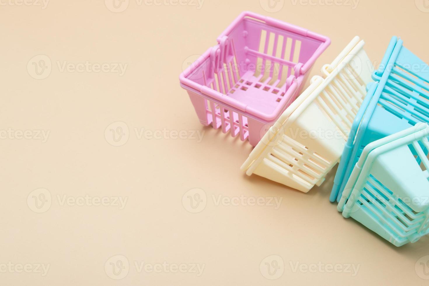 Colored empty shopping baskets on a beige background. Minimalism. Sales, shopping, prices concept photo