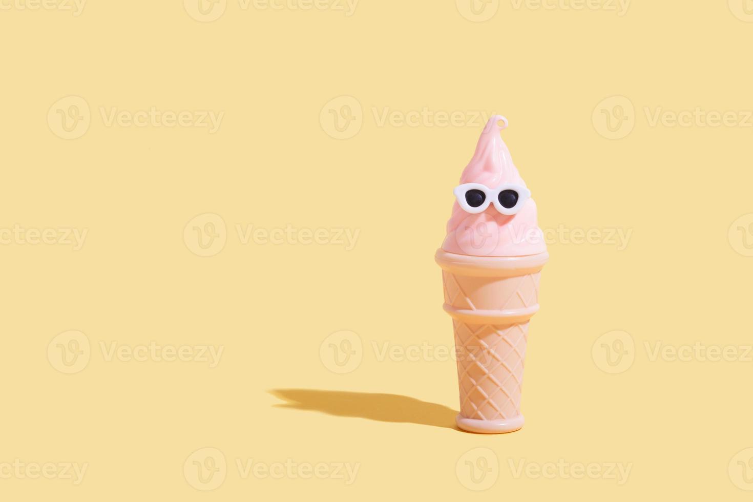 Ice cream cone in a waffle glass with sunglasses. Summer vacation in hot weather minimalistic concept photo