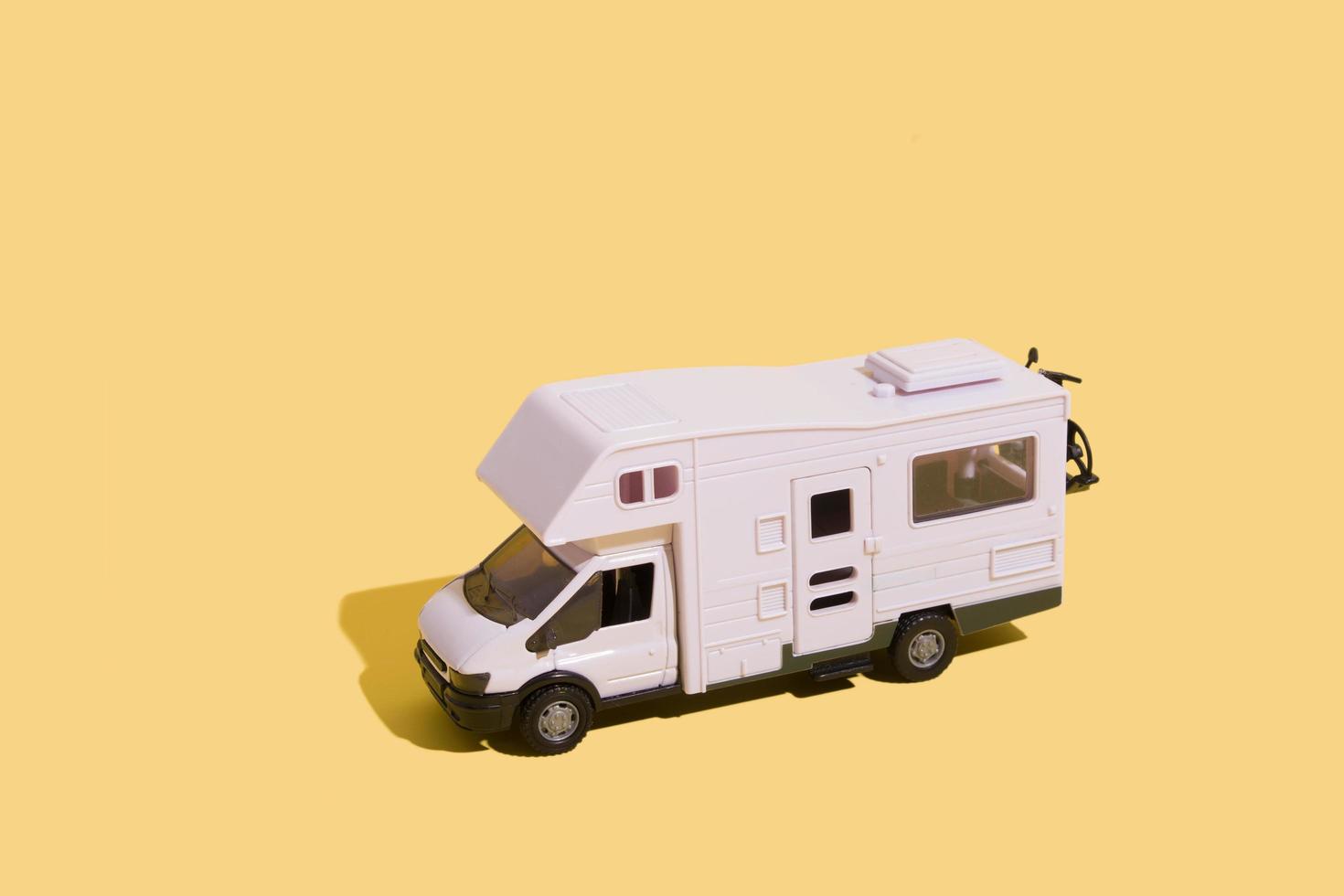 Irpin, Ukraine, June 10, 2021 - toy van on a yellow background. Minimalistic summer family vacation concept photo