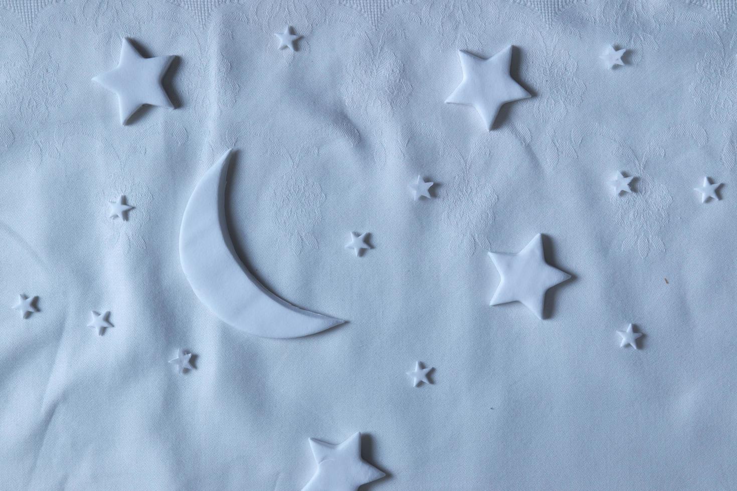 composición plana de la luna y las estrellas en la hoja. concepto creativo de ensueño foto