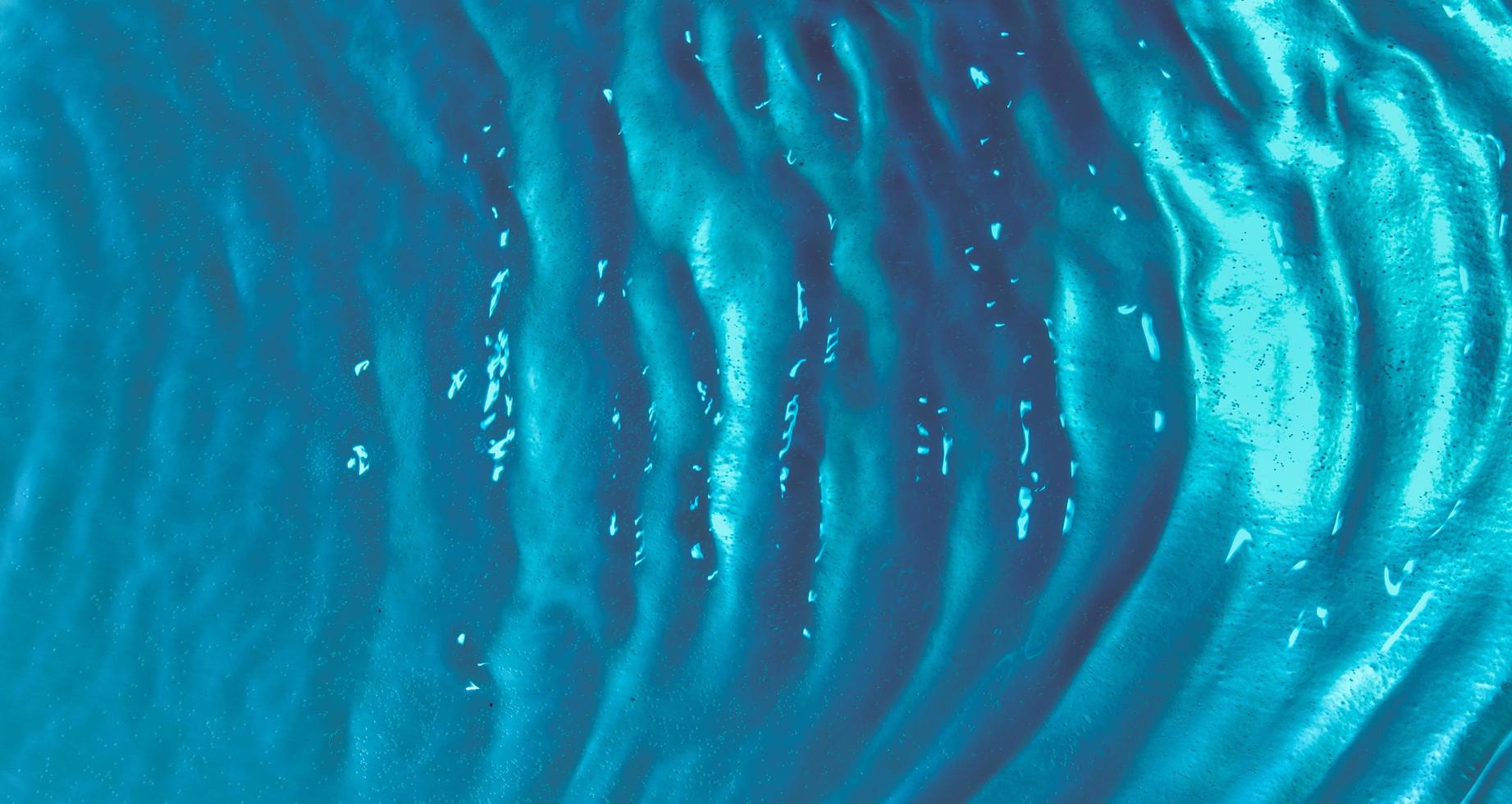 Water waves top view with bubbles on a turquoise background. Water surface texture photo