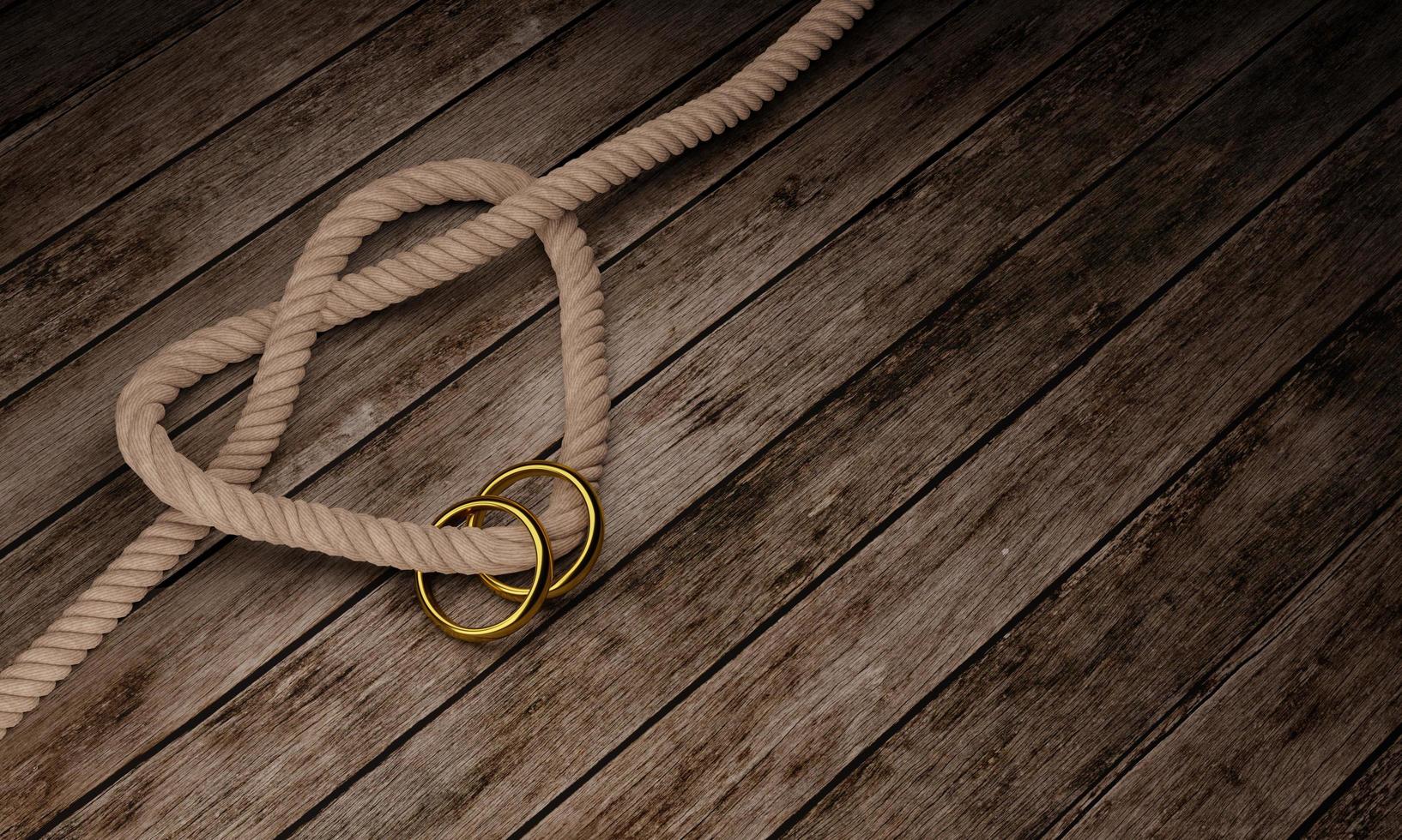 Heart shaped rope knot and golden ring on wooden surface and plank. Copy space and concept for photo