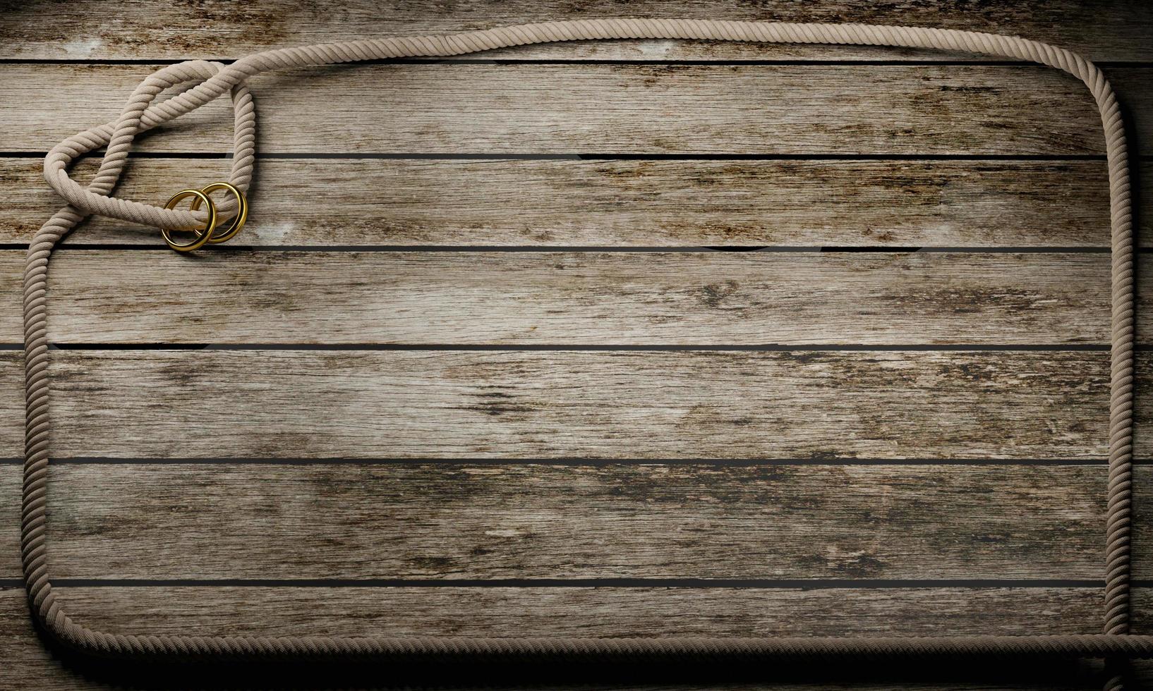 Heart shaped rope knot and golden ring on wooden surface and plank. Copy space and concept for photo