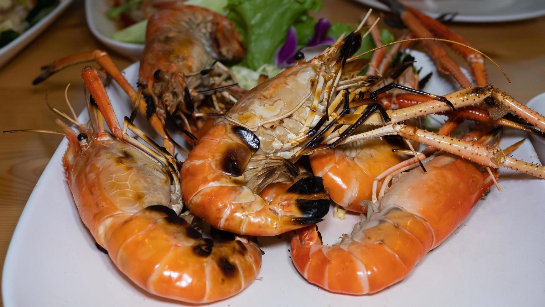 Grilled Shrimp Seafood has a slight black burn. Place them on a white plate at the restaurant. photo