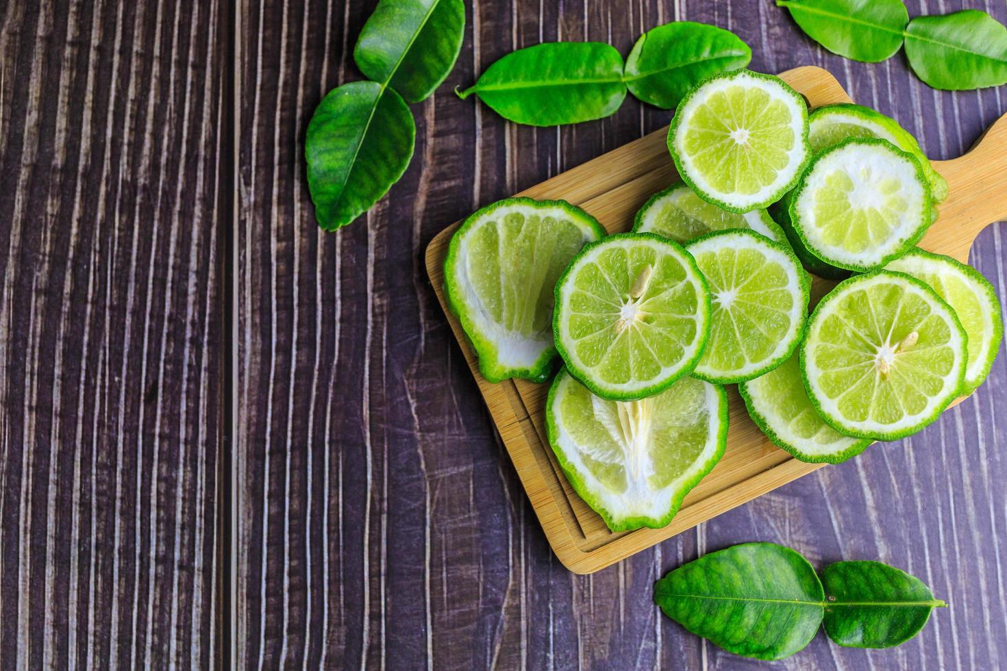 rodajas de fruta de bergamota fresca en madera foto